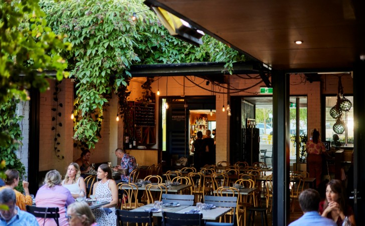 people dining in beautiful outdoor area with cascading greenery