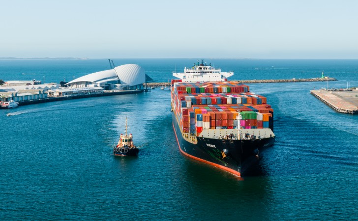 huge cargo ship sails into Fremantle Port with iconic WA Maritime Museum on the horizon