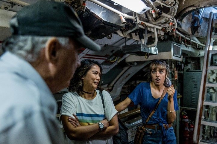 two people looked surprised and shocked as they talk with volunteer in submarine