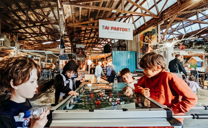 kids play foos ball in cool, colourful industrial style food markets