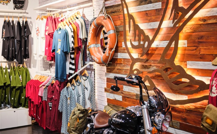 cool store with motorbike, life ring and motor-inspired clothing, with a large scale, back lit swallow art piece on wall