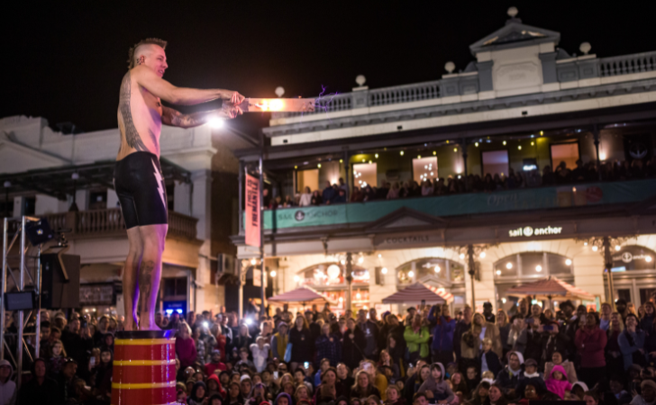 Fremantle International Street Arts Festival on Cappuccino Strip with large crowd and male performer standing on a drum 