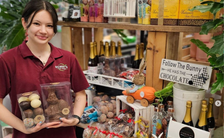 person hold chocolate eggs in a well-stocked store full of chocolates and easter treats