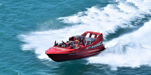 Cicerellos Jet Adventures red boat blasts through turquoise waters in Fremantle, near Perth, WA