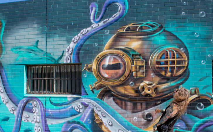 blue, green and bronze mural of octopus in a diver's helmet
