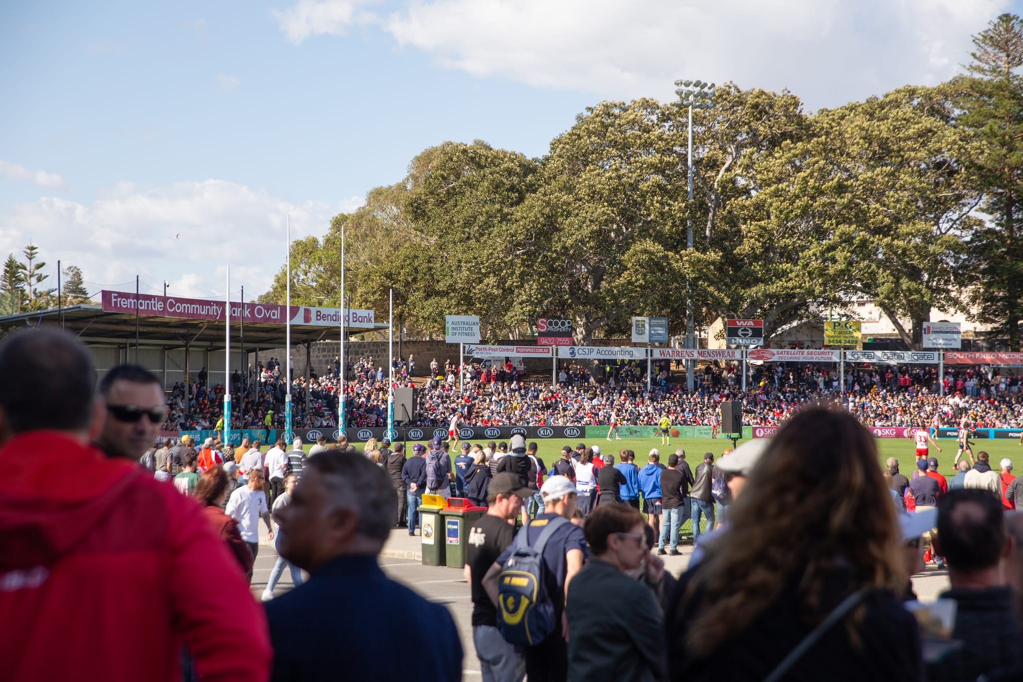 Fans watching a football game in a stadium. 