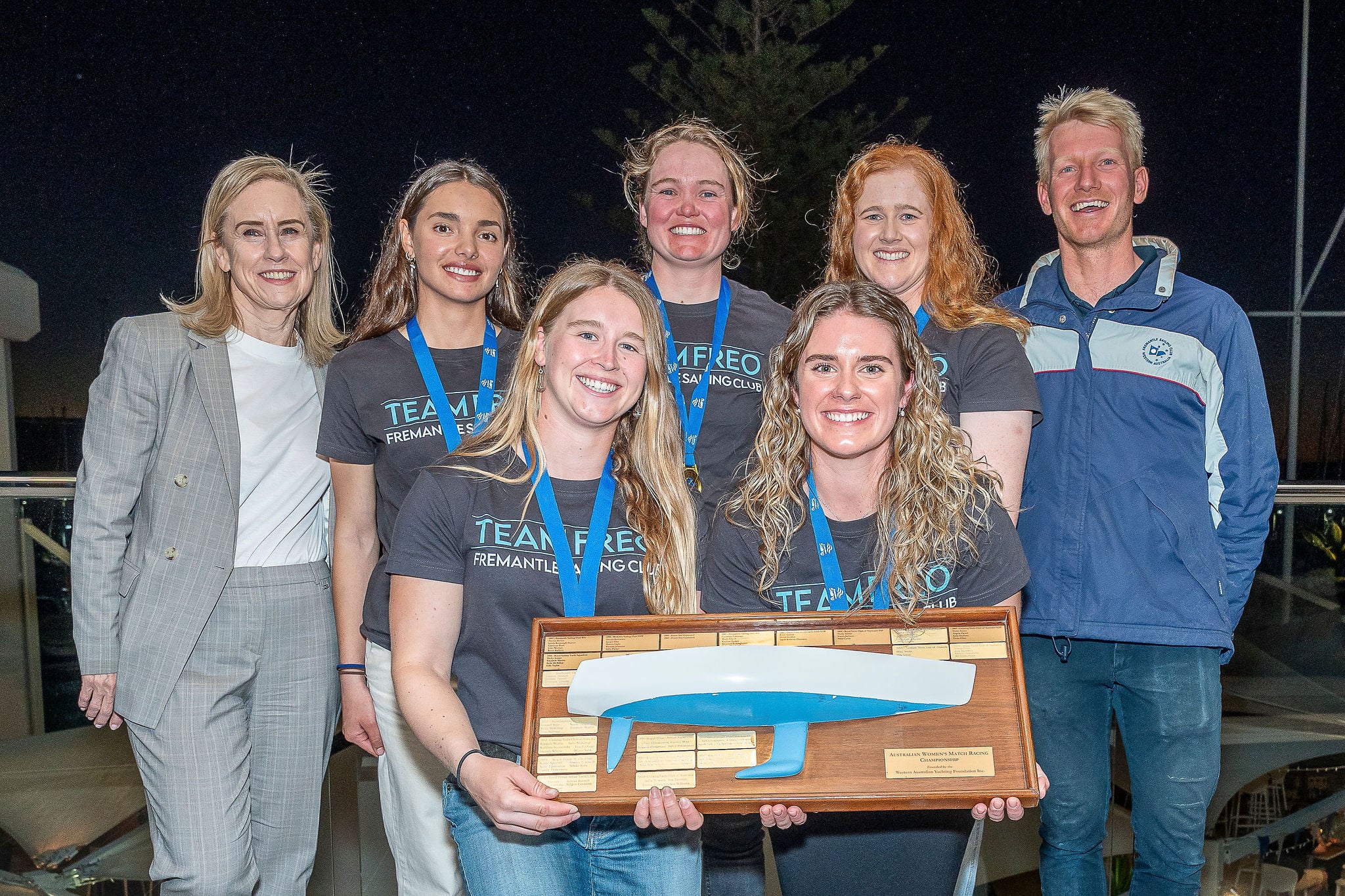 a group of women sailors holding a trophy 