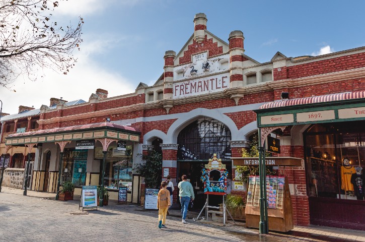 Entrance to the Fremantle Markets with 3 people walking through the red brick entrance off Market Lane