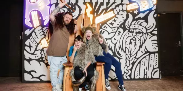 A young family pose with axes in front of the MANIAX Fremantle wall.