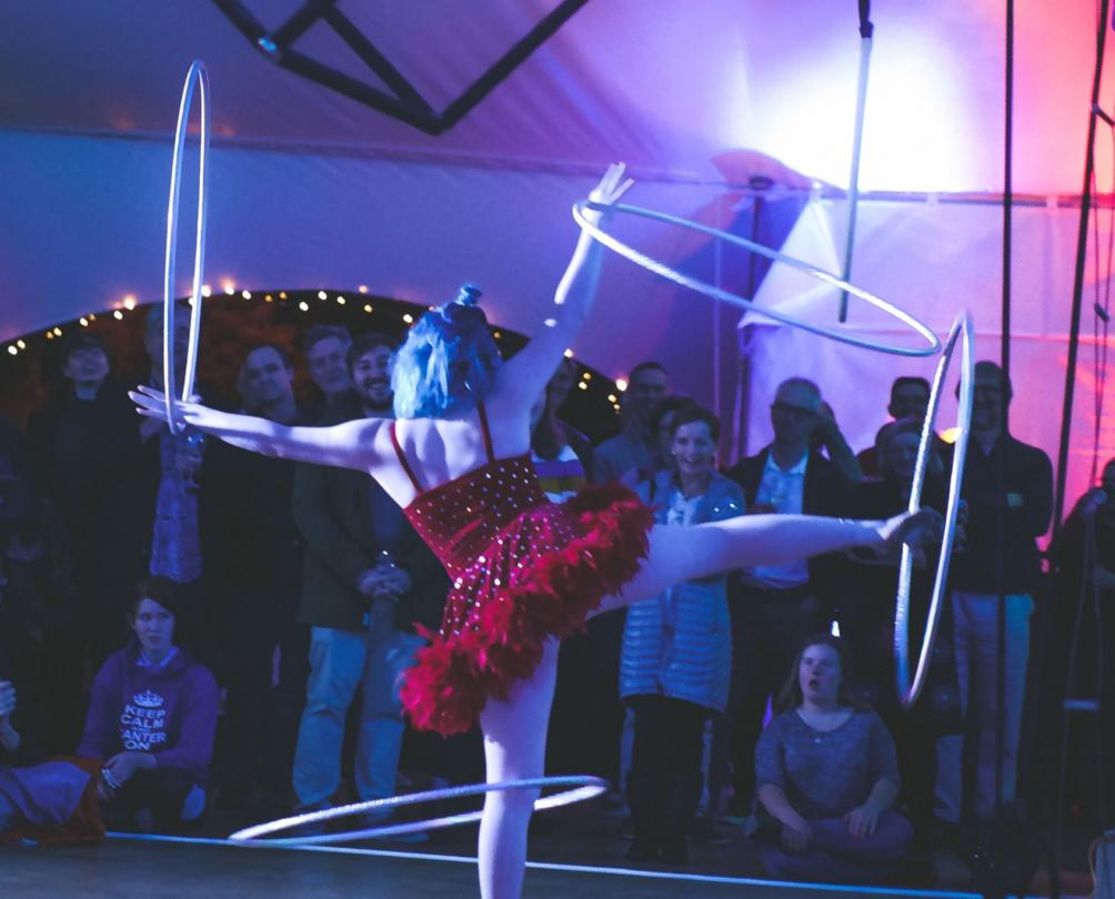 circus performer balancing hoops on arms and legs