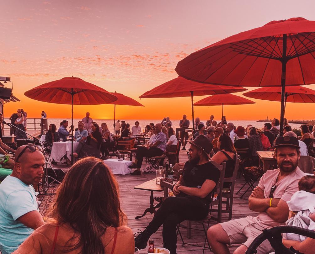 people sitting under umbrellas on the beach