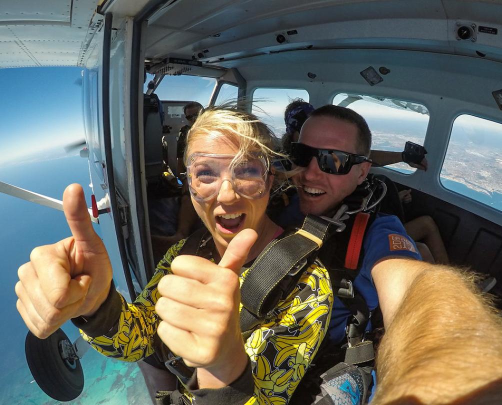 women doing thumbs up about to jump out of plane 