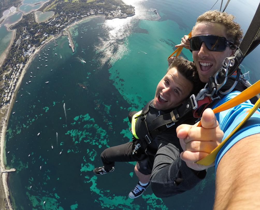 two people smiling while in the sky above rottnest island 