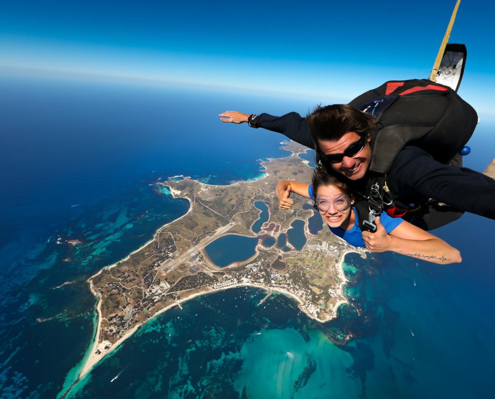 man and women tandem sky diving over rottnest island