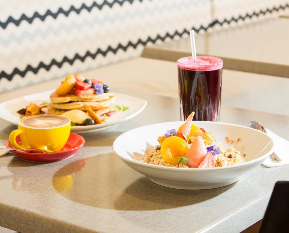 table setting with breakfast food. smoothie, coffee, porridge and pancakes