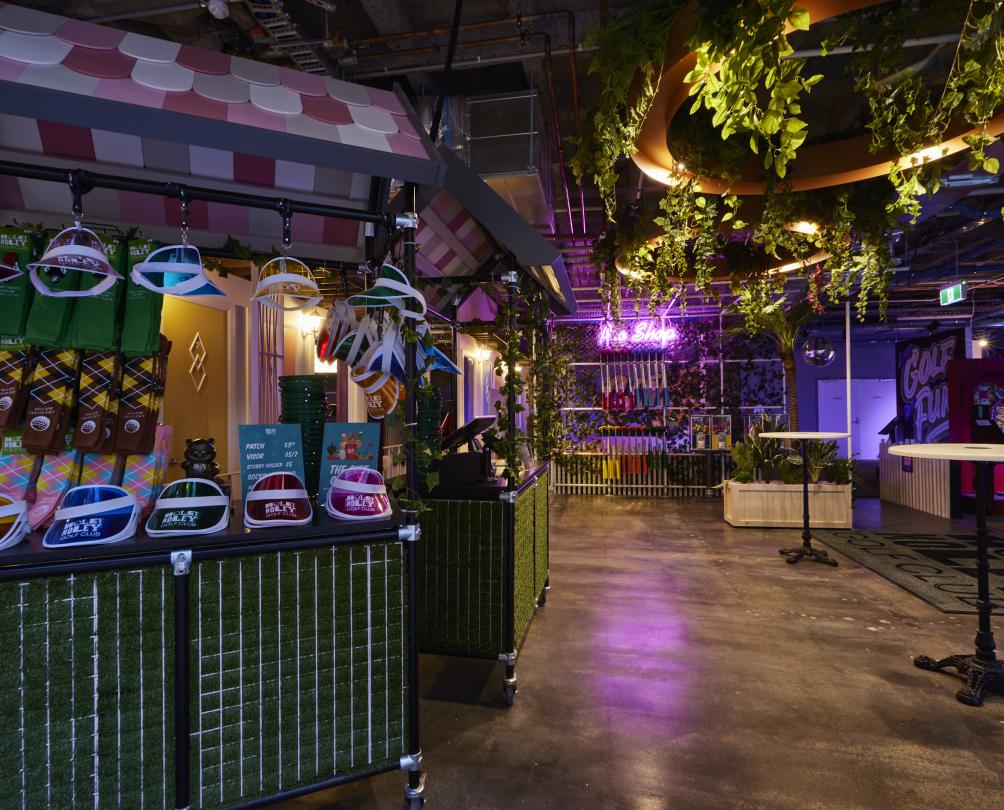 Holey Moley entry at FubLab Fremantle with tables, counter, coloured hats and plants hanging from the ceiling 