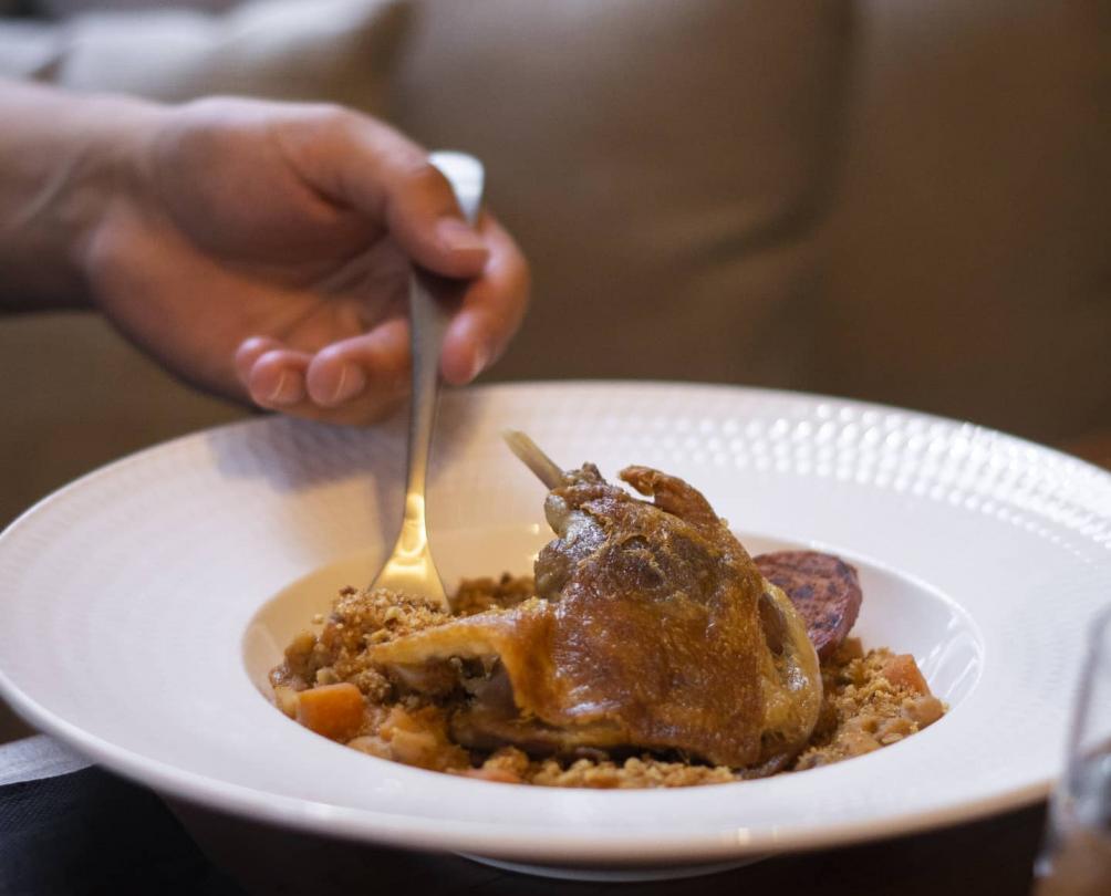 hand with fork digging into a delicious meal