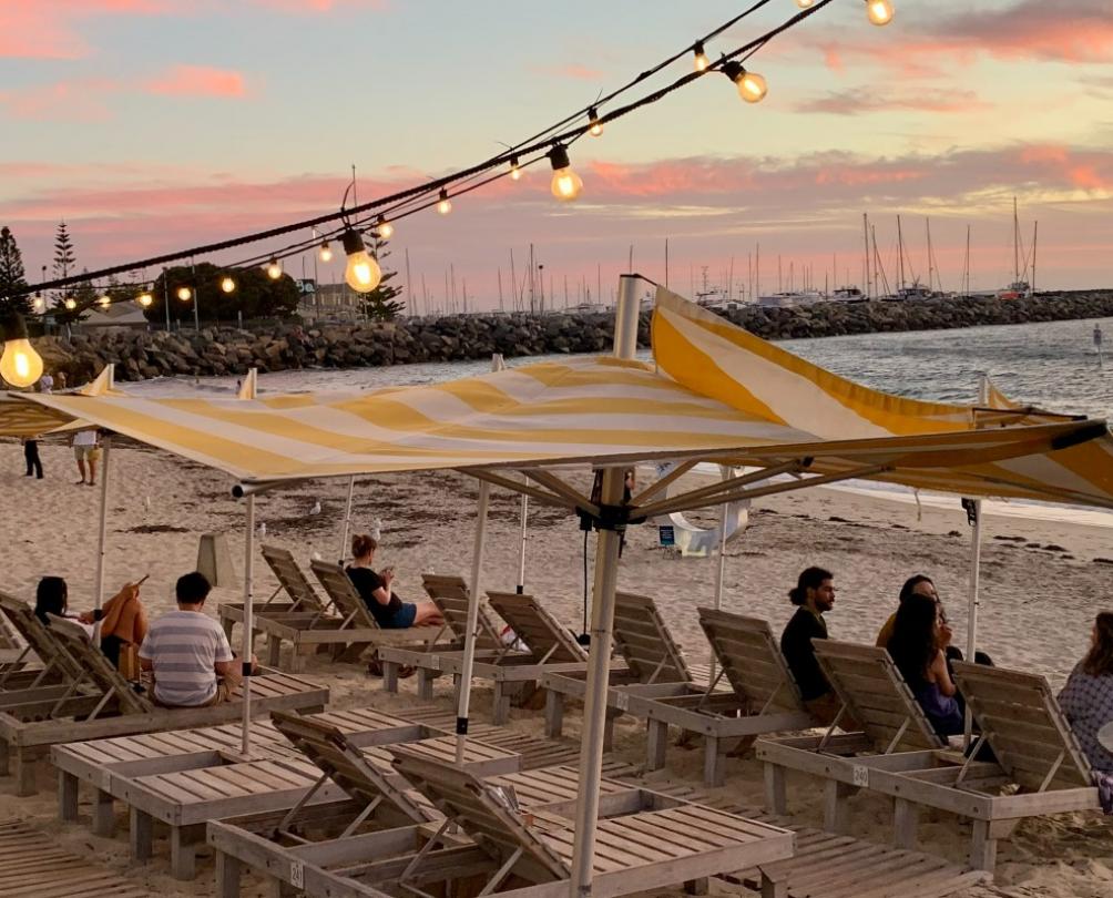 Bathers Beach Hose beach chairs on sandy beach right in front of ocean under pink sunset