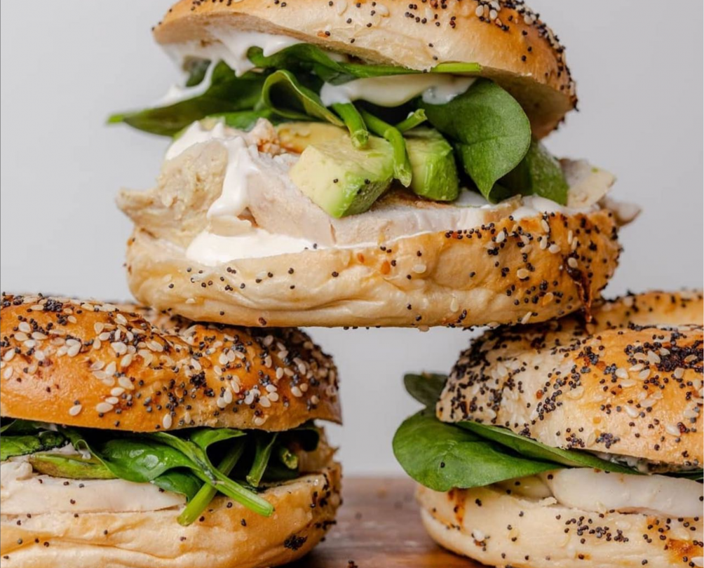 three poppyseed rolls stacked on top of one another, with avocado, mayo and saladsalad