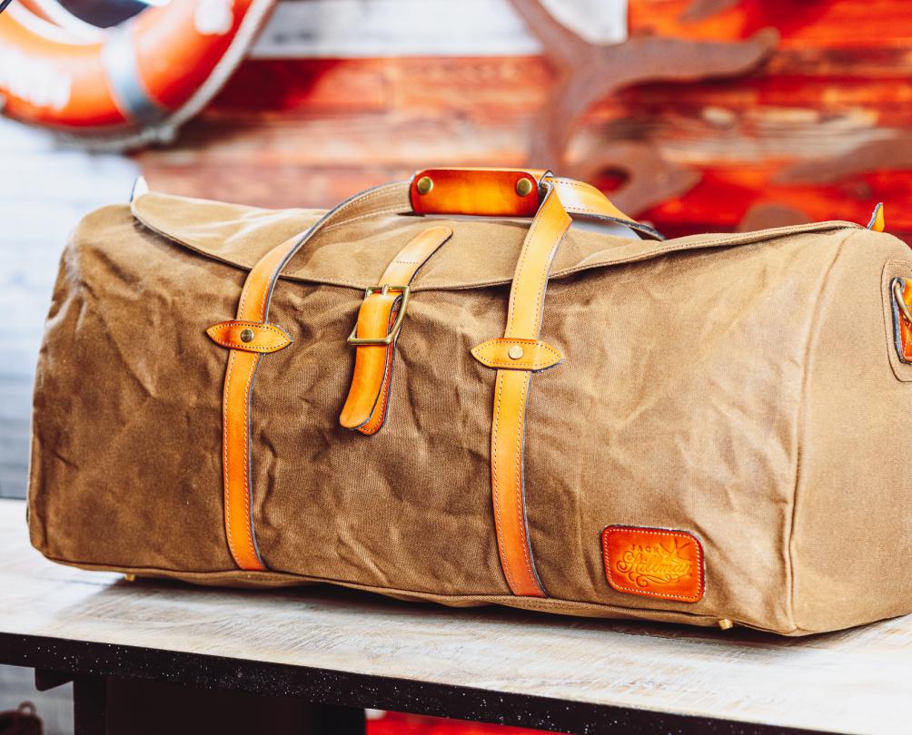 brown travel luggage in front of maritime styled background