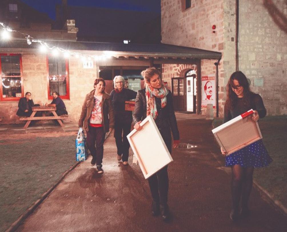 people admire their paintings while walking from evening class