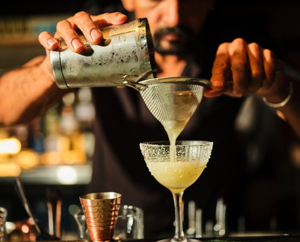 Male bartender pouring a cocktail at Al Lupo