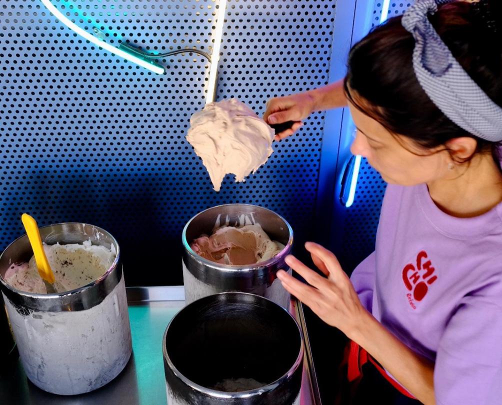 Woman in purple tshirt scooping gelato 