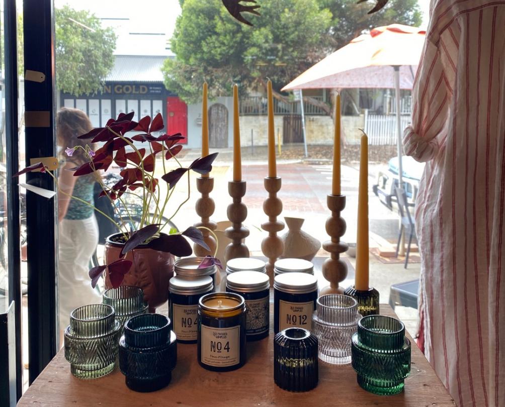 Candles and candle sticks displayed against a window facing Wray Avenue 