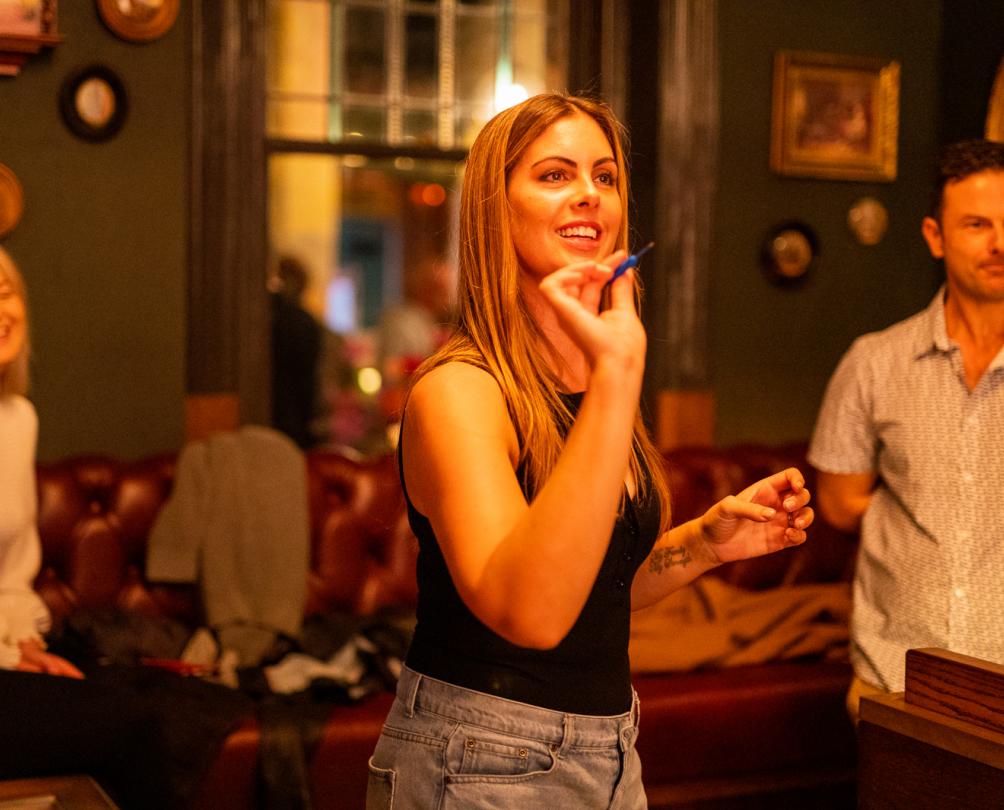 Woman about the throw a dart at Flight Club Fremantle