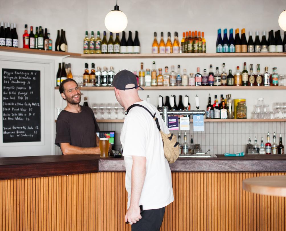 Bartender serving a beer to a male customer at Patio Bar