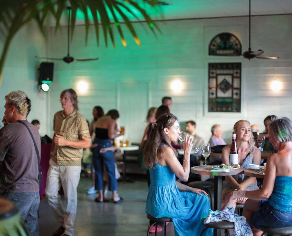 Interior shot of guests at Patio Bar standing and sitting enjoying food and drinks 