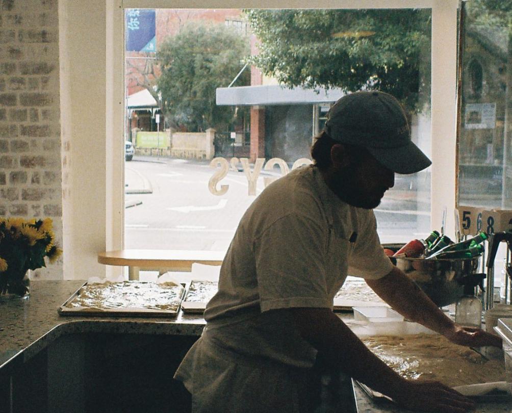 Barista making coffee at Peggy's with window behind