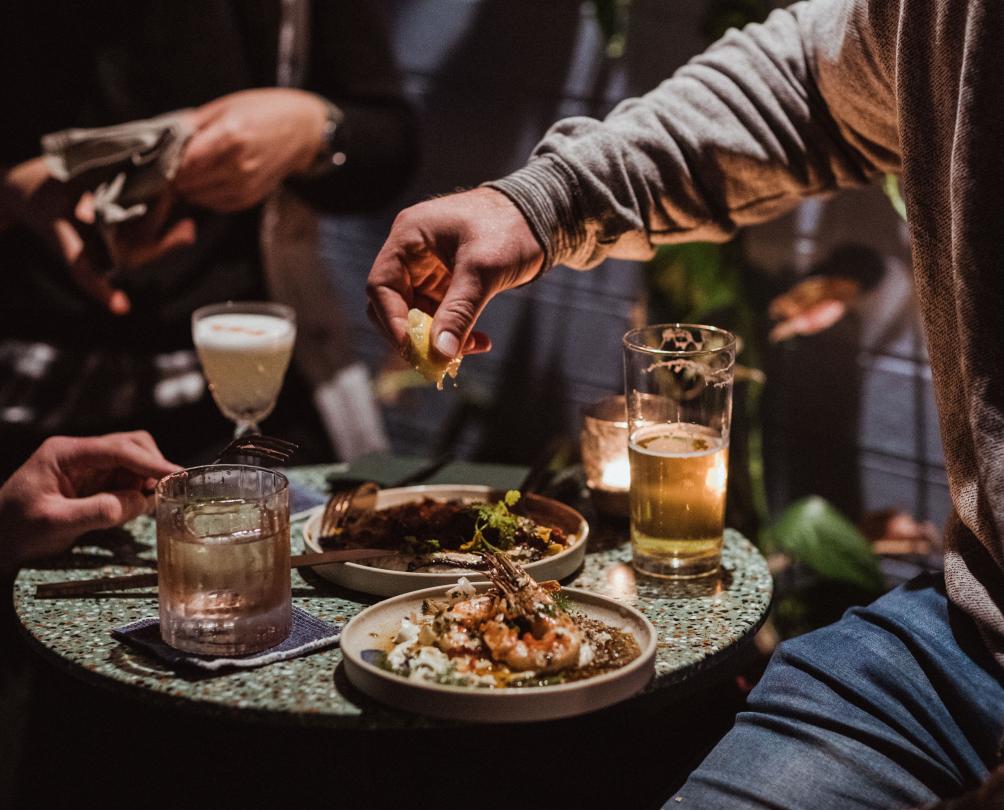 Plates of food and cocktails and beer on table at Wild in the Street, South Fremantle