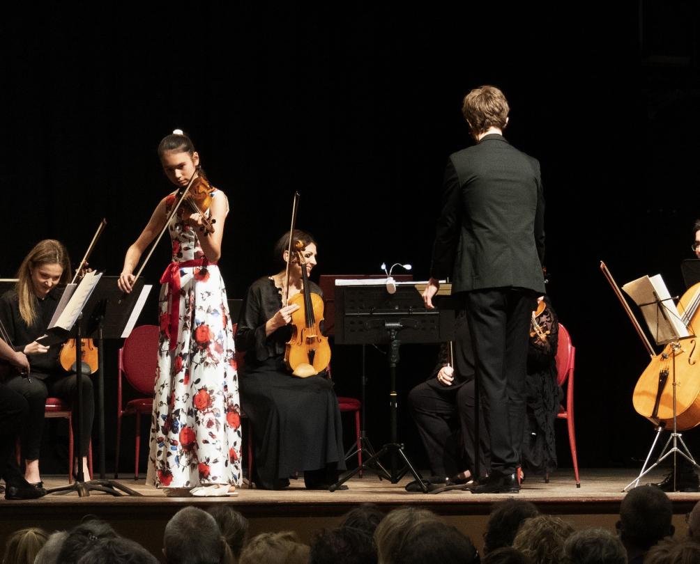 Ellie Malonzo performing with orchestra on stage at Fremantle Town Hall