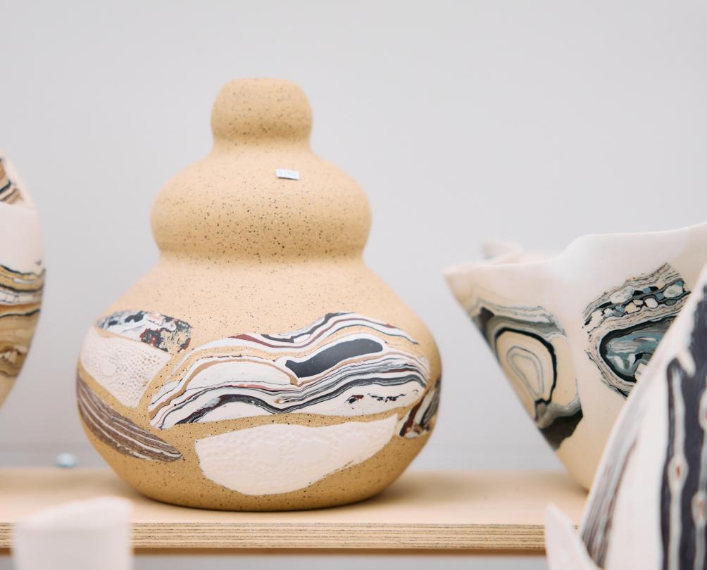 A decorative cream coloured ceramic with blue swirls on it.