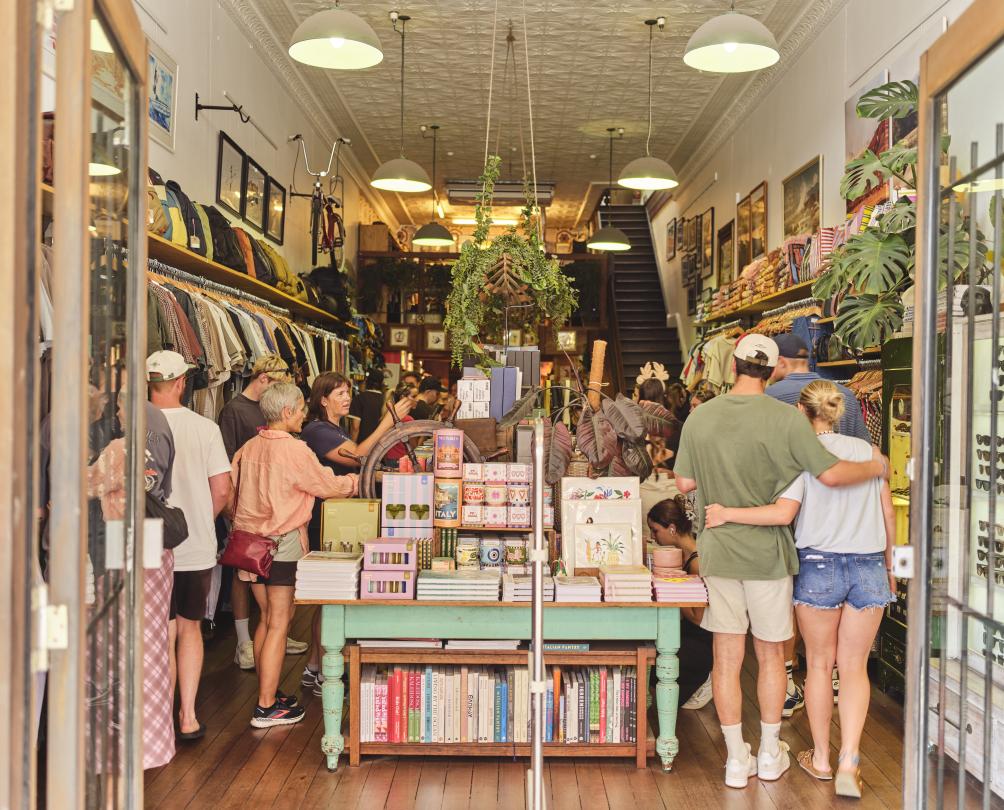 Store with a variety of items and lots of shoppers inside.