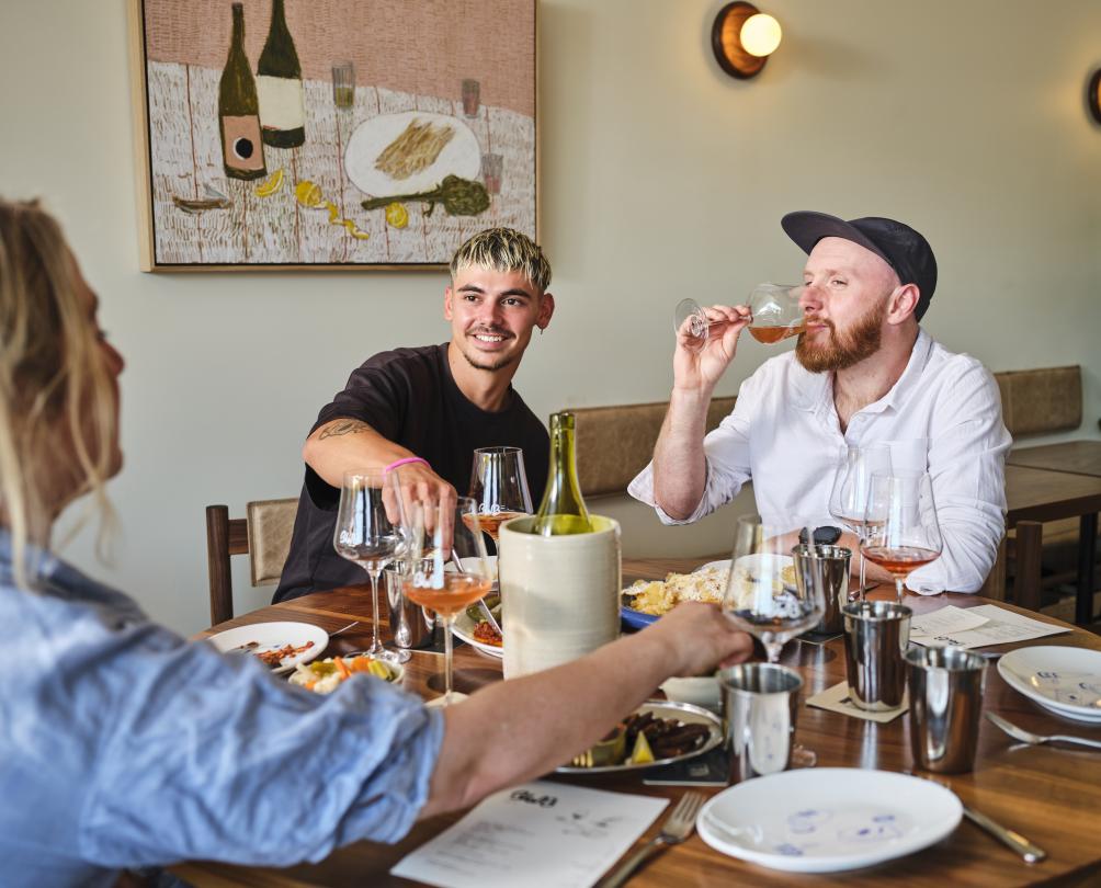 Three young friends dining inside a restaurant.