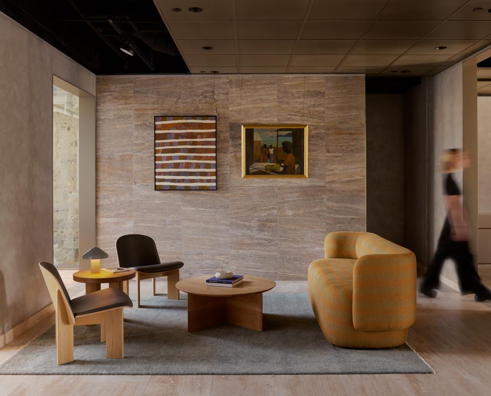 A hotel waiting room with plush yellow lounges and wooden furniture.