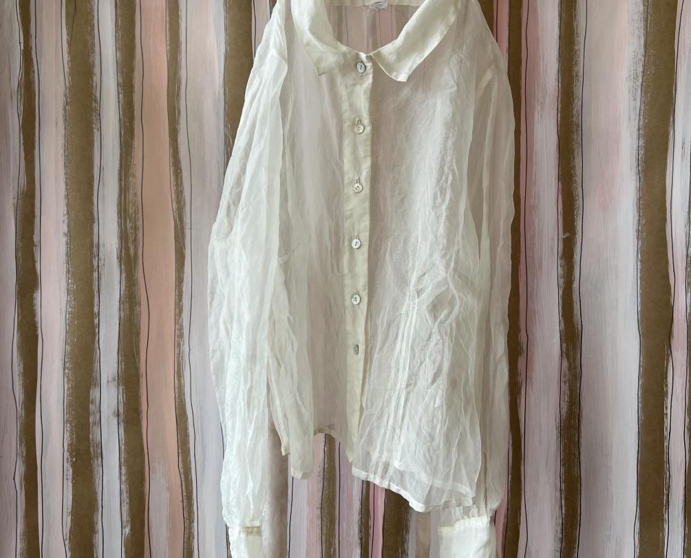 A white linen shirt against a curtained wall.
