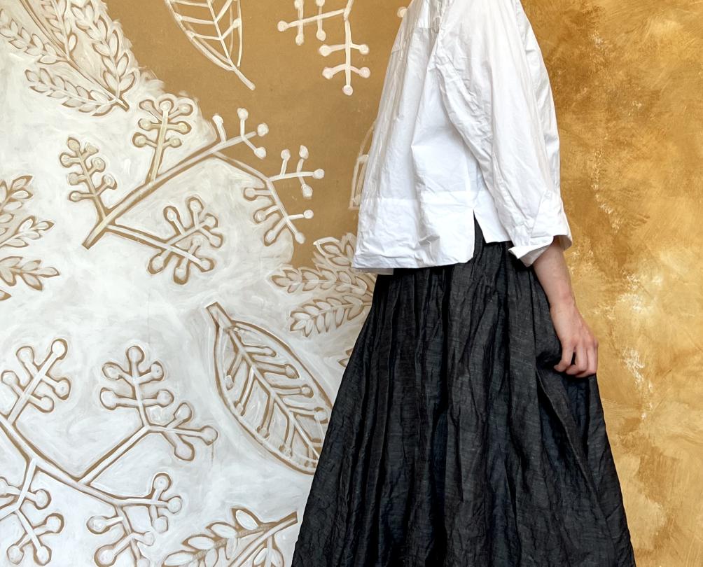 A woman wearing a white shirt and black skirt.