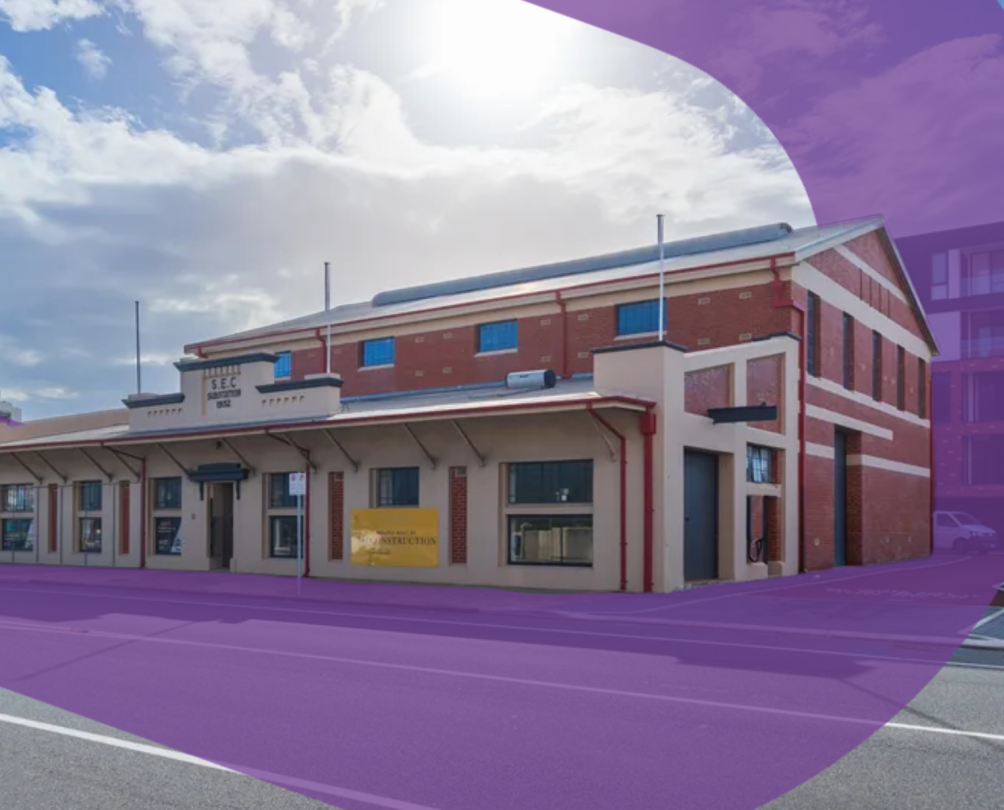 A large heritage brick building facing a road.