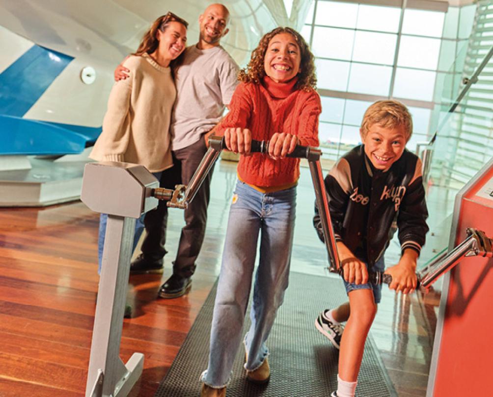 family playing with an attraction at a museum