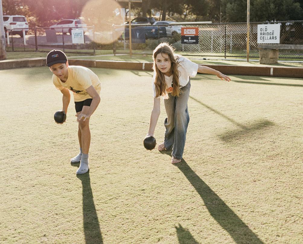 two kids playing lawn bowls 