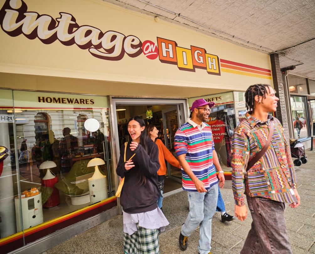 group walking out of shop on a street