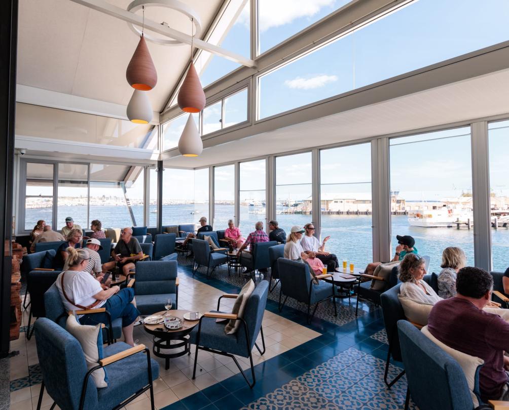 people sitting in a restaurant overlooking the water in Fremantle