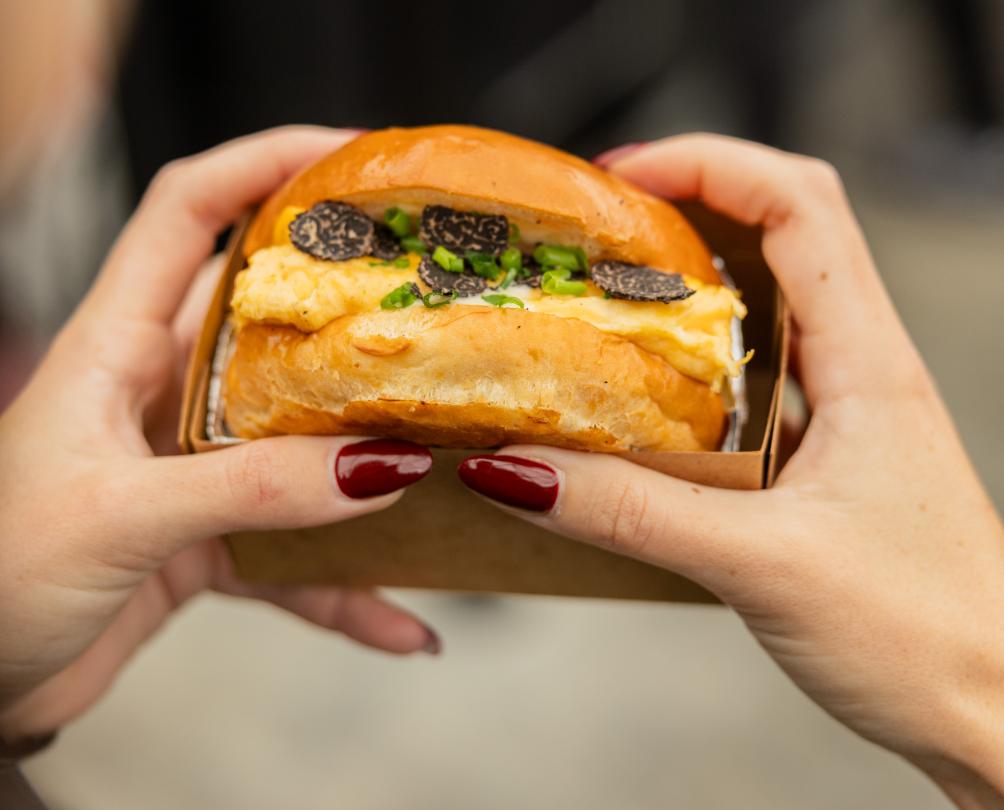 egg spot truffle burger in someone's hands