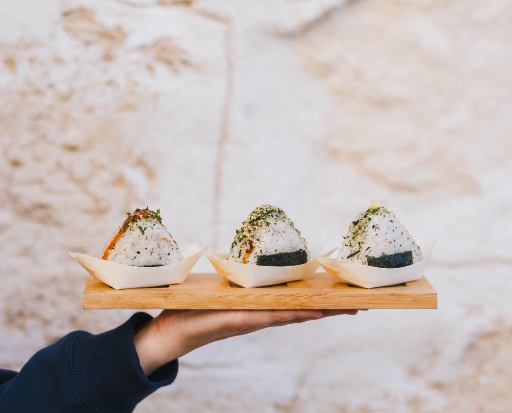 three signature truffle dishes on a wooden plate being held on a hand