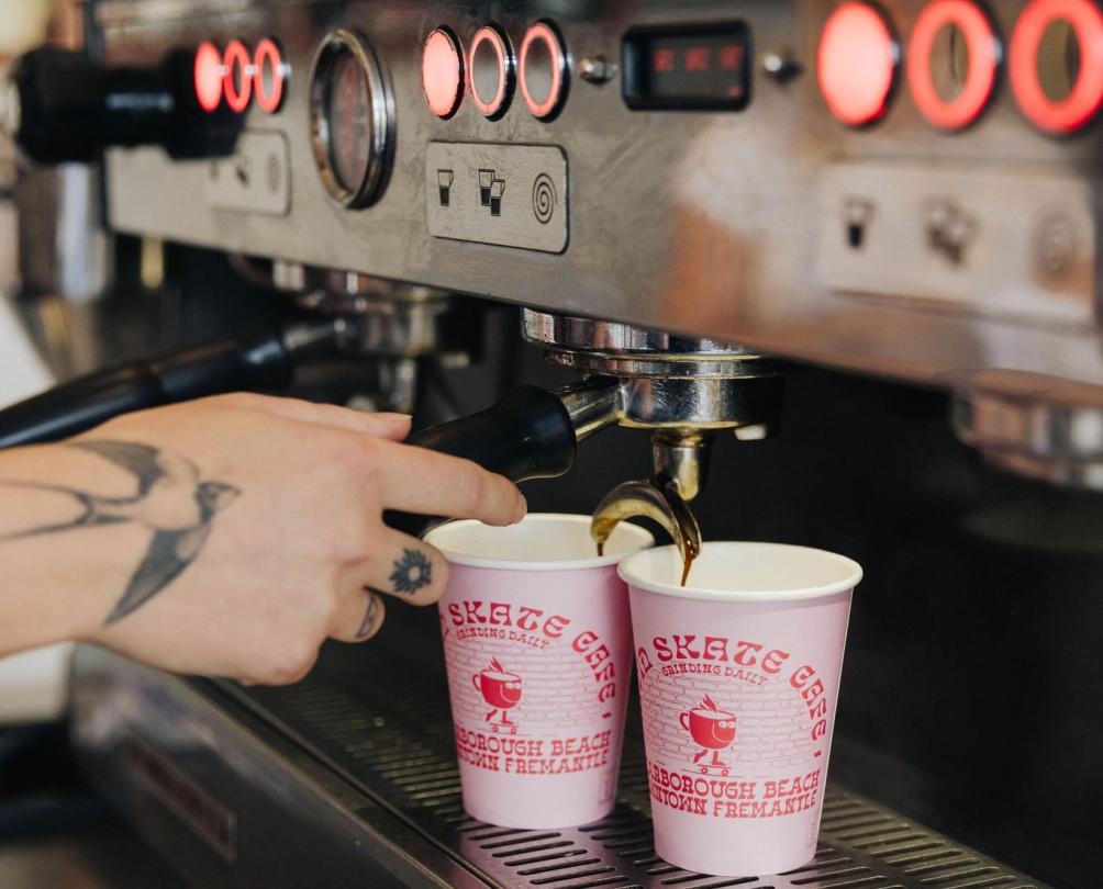 two coffee cups under a coffee machin