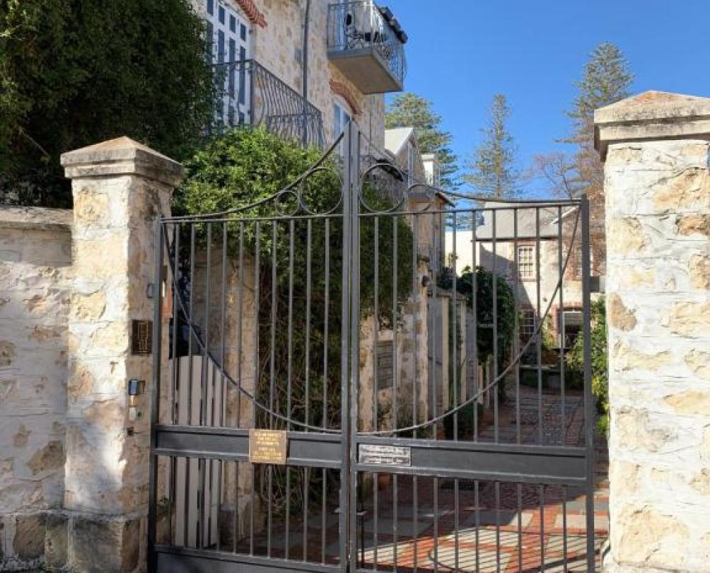 old metal gates and big stone pillars at the entrance of a bed & breakfast