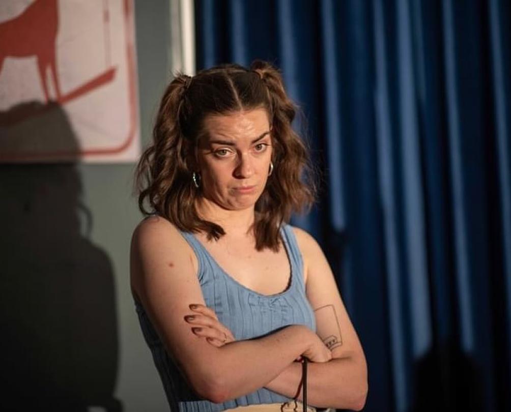a women with pigtails making a funny face on a stage